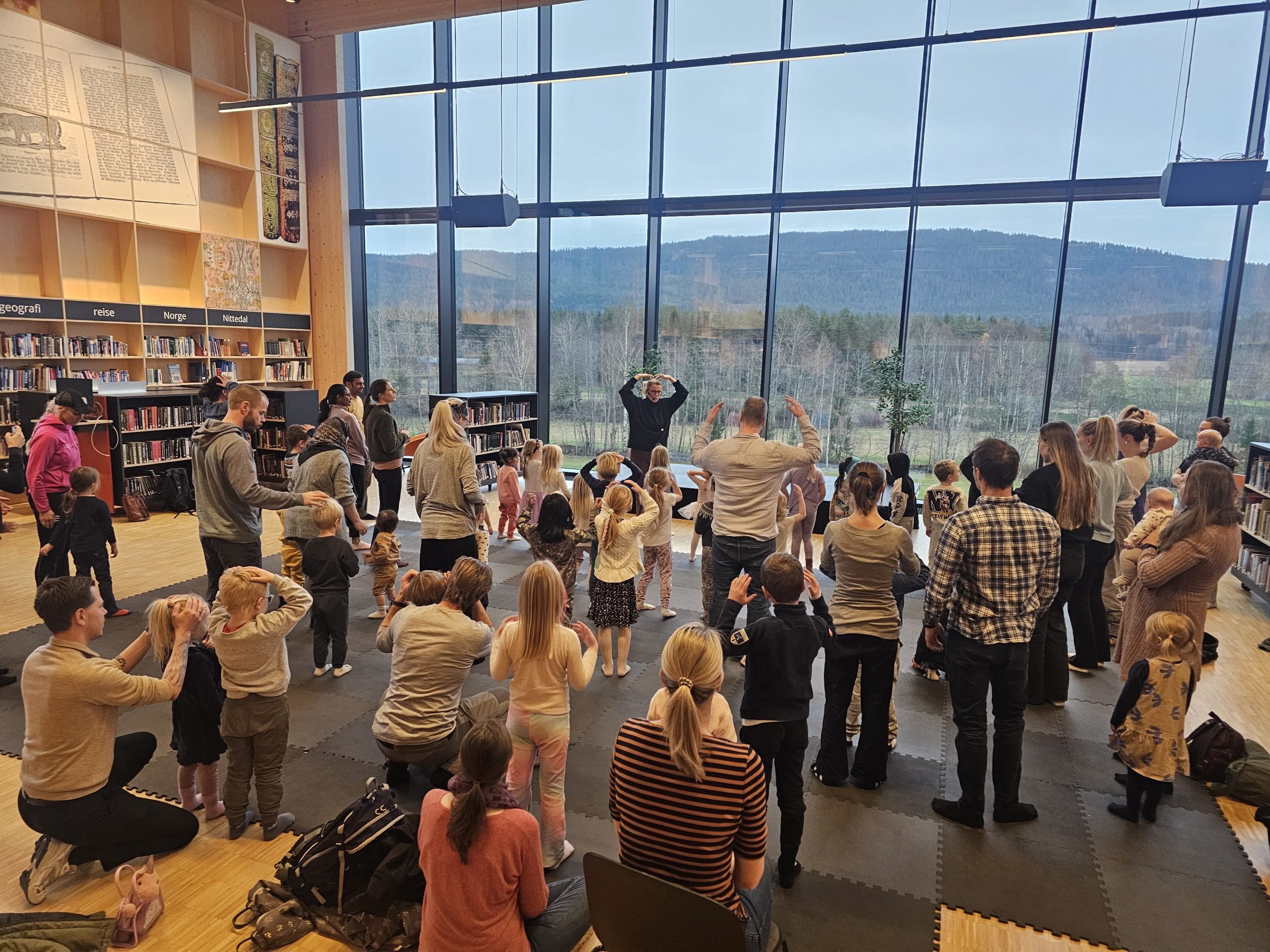 Mange barn gjør yoga sammen inne på et bibliotek